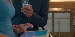 在购物中心使用手机和平板电脑的人