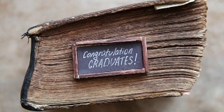 祝贺毕业生，桌上放着文本和古董书