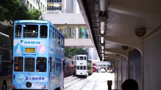 标志性的香港有轨电车概念。人们在电车站等候，后面有一辆车驶近视频素材模板下载