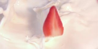 两段草莓落入牛奶的视频，慢镜头