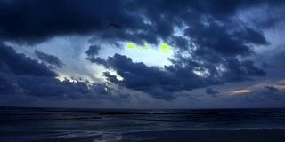 黄昏时分，海滩上的云在地平线上快速移动