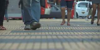 步行或通勤上班的人群。低角度拍摄的脚和腿行走在非常炎热的夏天