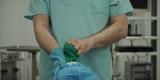 男性外科医生在手术后脱去手套和长袍
