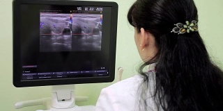 女医生放射学家在医院的电脑显示器屏幕上分析医学影像。放射学病房。放射科医生对病人进行了分析。医生进行体检