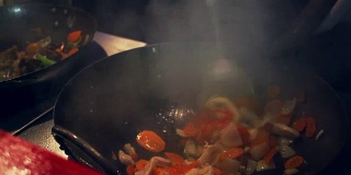 锅做饭。亚洲烹饪食物。厨师用平底锅煮蔬菜