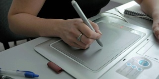 一名女子用笔、平板电脑、数字化仪和触控笔作画