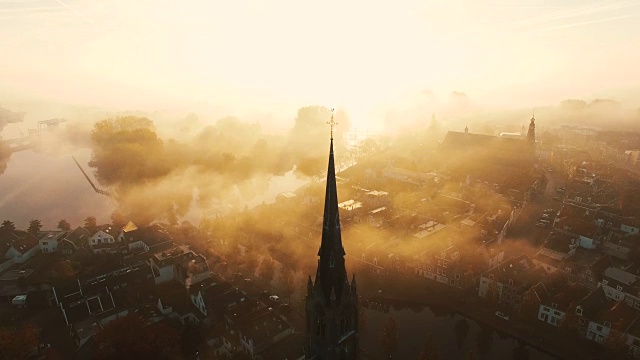 摄像机向上倾斜，显示一个十字架在迷雾笼罩的基督教教堂的顶部