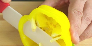 Man slicing yellow bell pepper, macro video
