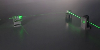 连续波绿色激光通过光学元件传播。激光安全。