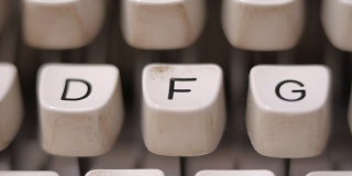 男性用手指在老式老式打字机上打出字母F。