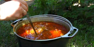 在木炉上用大锅煮羊肉汤。