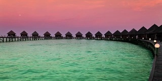 日出时，海面上的房屋。马尔代夫