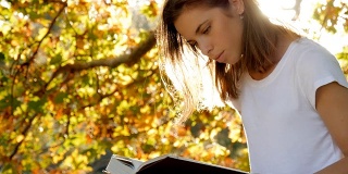 美丽的年轻女学术学生读书研究秋天秋天公园