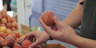 男人白天在蔬菜市场买桃子