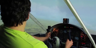 年轻人驾驶飞行模拟器，操纵方向盘，玩电子游戏