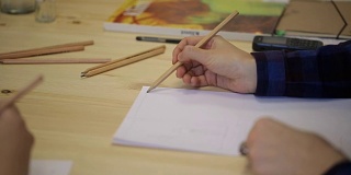 女人的手用铅笔在纸上画成一条线