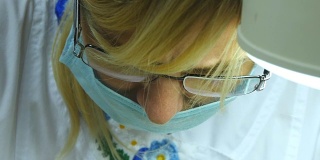 近距离拍摄的女医生戴着防护眼镜的肖像。女性戴着医用口罩。美容师或治疗师在工作