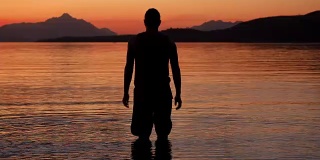 日落时湖边一个人的剪影