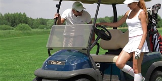 男人和女人坐在高尔夫球车里