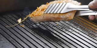慢动作烤架上的烤红鱼牛排鲑鱼