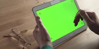 多莉:一位老年妇女手中的白色平板电脑(绿色屏幕)