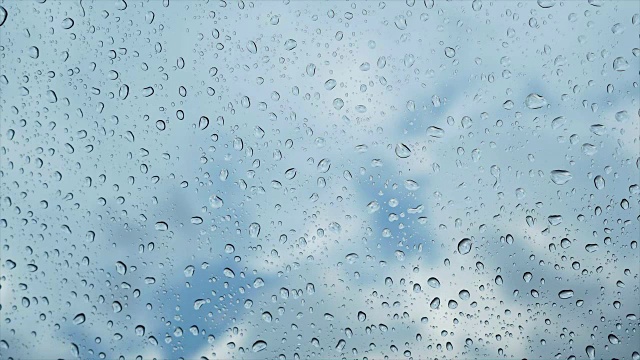雨点落在玻璃上，蓝天为背景