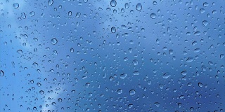 雨点落在玻璃上，蓝天为背景