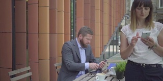 从智能手机到平板电脑，商人在户外做笔记。替身。