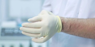 医生是一个男人戴上一次性白手套的特写
