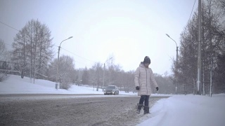 年轻女子在冬天过马路。Slowmotion视频素材模板下载