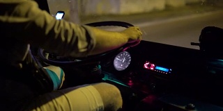 公交车司机晚上在城市街道上使用智能手机乘坐城际长途汽车