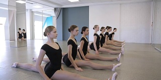 在舞蹈课上，年轻的体操运动员一个接一个地坐在麻绳上