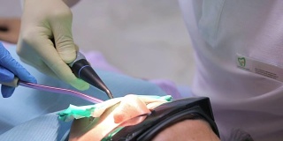 牙医用一个牙科附件将水倒进病人的嘴里，护士工作的吸力