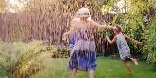 一群无忧无虑快乐的孩子在花园里玩耍。光着脚在草地上奔跑，任凭水流或雨水冲刷