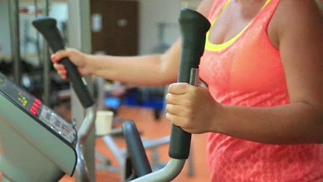 女人在健身房的步进机上训练。健康和健身的概念