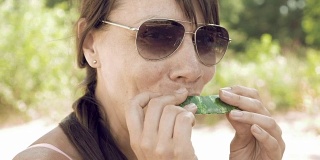 夏天，Smiley woman在户外吃西瓜