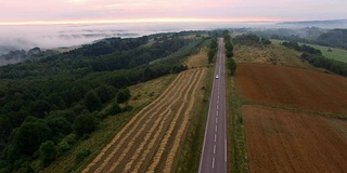 雾蒙蒙的乡村公路上的汽车鸟瞰图