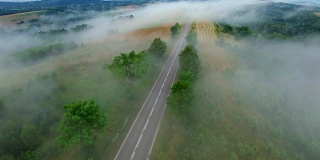 雾蒙蒙的乡村公路上的汽车鸟瞰图
