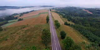 雾蒙蒙的乡村公路上的汽车鸟瞰图