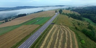 雾蒙蒙的乡村公路上的汽车鸟瞰图