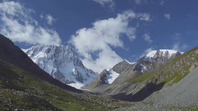 风景有雪山、云和蓝天。天山、吉尔吉斯斯坦