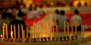 佛寺佛日。人们点燃蜡烛、鲜花和熏香。泰国普吉岛那卡兰寺。慢动作