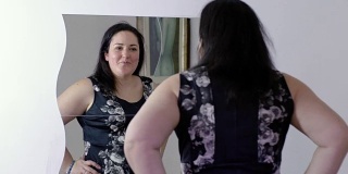 快乐超重的女人出门前照镜子:看她的衣服