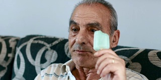 老人坐在沙发上吃着冰淇淋:放松，冰棒，夏天，热