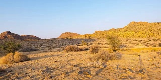 彩色的日出在纳米比亚沙漠，澳大利亚，纳米比亚，非洲。晴朗的天空，发光的岩石和山丘，时间流逝视频。