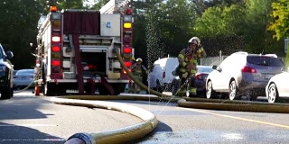 消防应急人员在救援行动中关闭水龙带喷水。