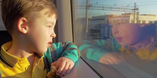 在俄罗斯的圣彼得堡，火车上坐着一个小男孩，他拿着一个玩具望着窗外