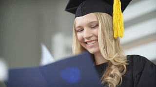戴学士帽和学士服的毕业生。有文凭的毕业生视频素材模板下载