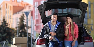 微笑的夫妇坐在后备箱的现代汽车
