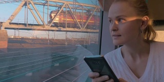 在俄罗斯圣彼得堡，火车上坐着年轻的女孩，看着窗外